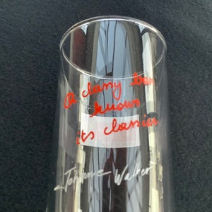 May include: A clear glass with red writing that says "A classy bar knows it's classics." The writing is signed "Tom Hanks Walker".
