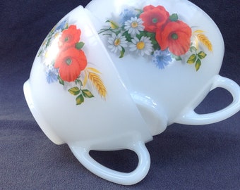 Twee vintage Arcopal thee- of koffiekopjes met klaprozen en wilde bloemen.