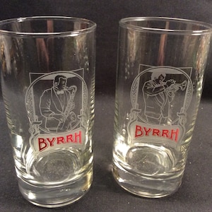 May include: Two clear glass tumblers with etched images of a man playing a saxophone and a man playing a trumpet. The glasses have the word "BYRRH" in red lettering on the bottom.