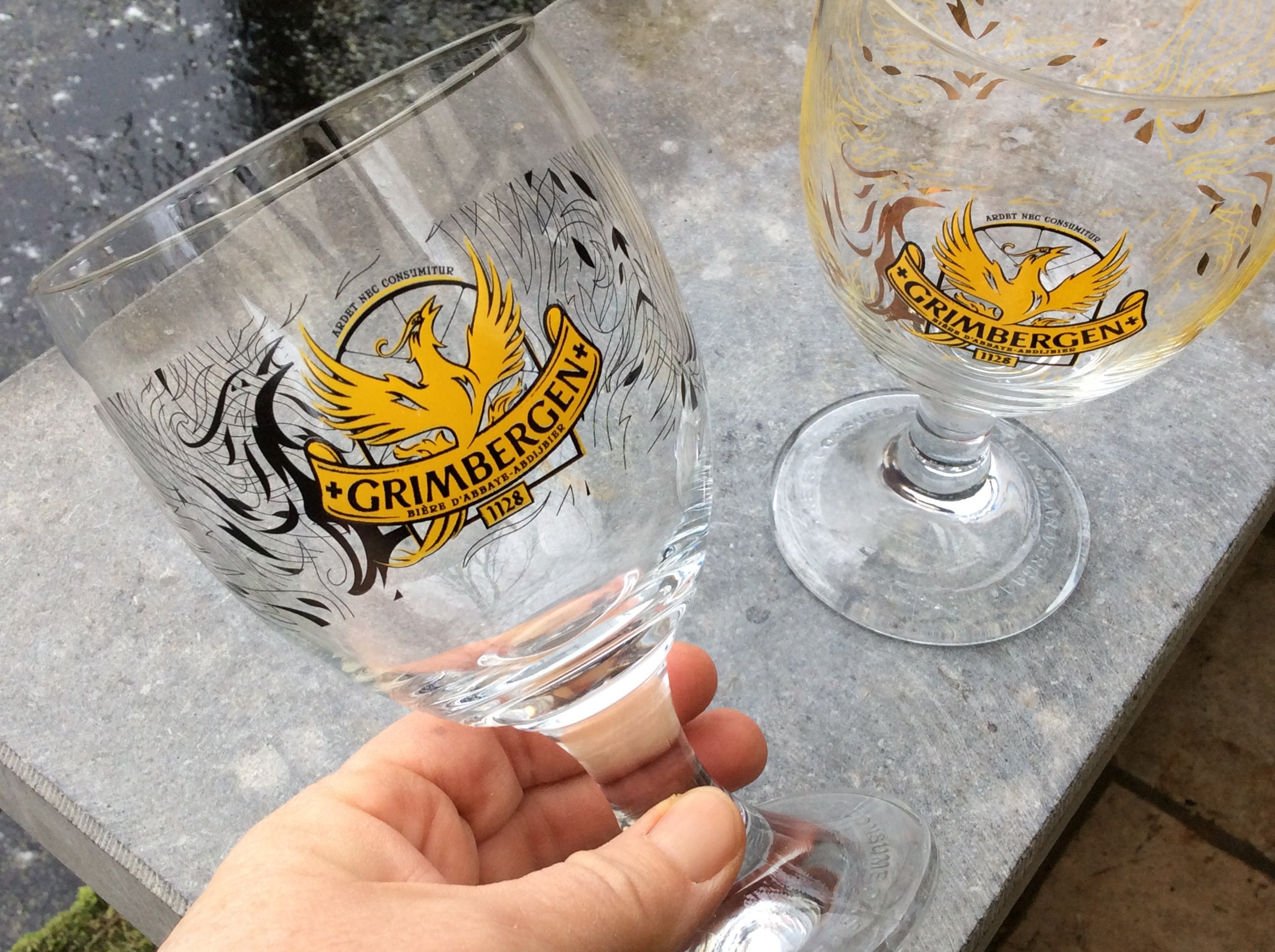 2 Beautiful Grimbergen 33 cl glasses chalice on foot with the Phoenix  rising from the ashes logo, 2 glasses with a different color pattern