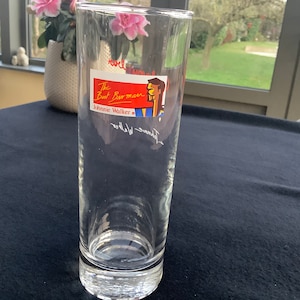 May include: A clear glass with a red, white, and blue label that says "The Boat Barman Johnnie Walker".