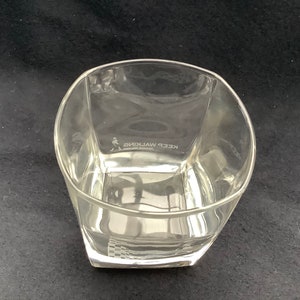 May include: A clear glass tumbler with a square base and rounded edges. The glass has the words "KEEP WALKING" etched on the side.