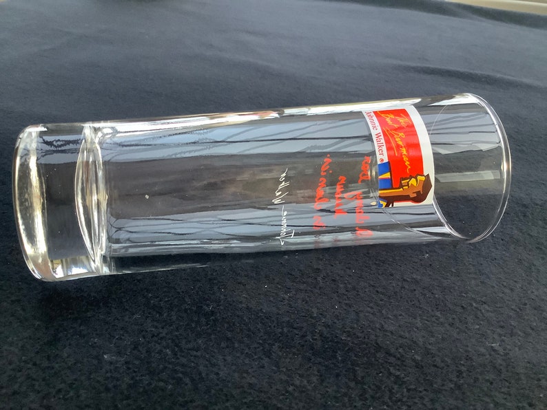 May include: A clear glass tumbler with a red, white, and blue label that reads "Johnnie Walker Red Label" and "Keep Walking".