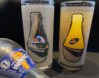 A beautiful set of 2 matte gray orangina glasses with the image of a bottle