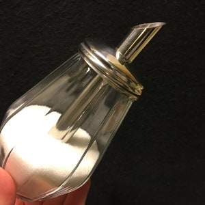 A vintage design of a sugar/sprinkle and honey or creamer dispenser, by UwO, made in Germany.