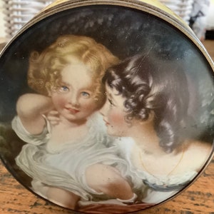 A lovely little round romantic tin with the image of two girls named &quot;Nature&quot; by sir Thomas Lawrence