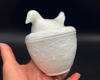 A vintage Avon, milk glass Dove on Nest Storage Jar with Lid, White Bird Sitting on Eggs.