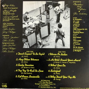 Op de afbeelding: De achterkant van een vinylalbum van Greg Kihn. De albumhoes toont een zwart-witfoto van de bandleden in een opnamestudio. De albumtitel is "Don't Expect To Be Right" en het album wordt toegeschreven aan Greg Kihn. De albumhoes vermeldt de muzikanten en de titels van de nummers op het album.