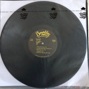 Op de afbeelding: Zwarte vinylplaat met een gouden label. Het label heeft de tekst "Beserkley" en "Home of the Hits" in een gestileerd lettertype. De plaat is gelabeld met "BZ-0048" en "Stereo 2". De tracklist bevat "Was Or Ball", "We Will Break Your Heart", "What Goes On", "Salified" en "Why Don't You Try Me".