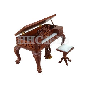 May include: A miniature wooden grand piano with an open lid, intricate carvings, and a white ivory keyboard. It comes with a matching stool with a white cushion.