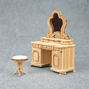 May include: A wooden vanity set with a carved mirror and two drawers. The vanity has two doors and a small stool with a white top.