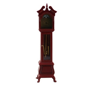 Puede incluir: Un reloj de pie de madera roja con una puerta de vidrio y detalles dorados. El reloj tiene un diseño tradicional con un péndulo y pesas.