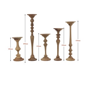 May include: Set of five wooden candle holders in various sizes and styles. The tallest candle holder is 172 mm tall, the shortest is 105 mm tall.