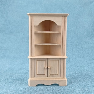 May include: A wooden corner cabinet with two doors and two shelves. The cabinet is unfinished and ready to be painted or stained.