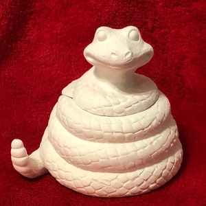 Könnte beinhalten: Weiße Keramik-Klapperschlangenfigur mit einem gewundenen Körper und einem erhobenen Kopf. Die Figur ist unbemalt und bereit zum Dekorieren.