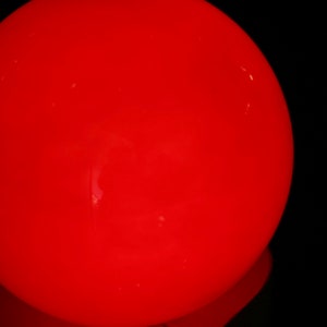 May include: A large, bright red, round light bulb.