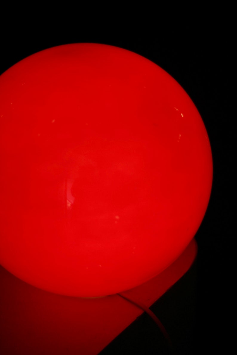 May include: A large, bright red, round light bulb.