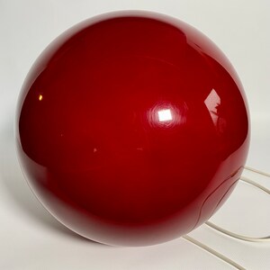 May include: A large, red, spherical lamp with a white cord.