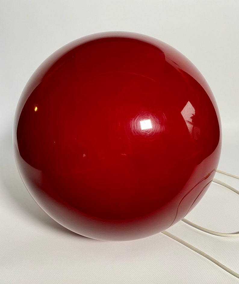 May include: A large, red, spherical lamp with a white cord.