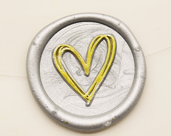 May include: A silver wax seal with a gold heart design.