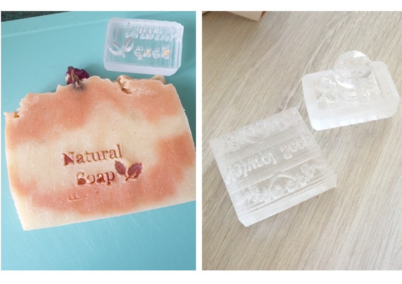 May include: Three clear plastic soap stamps with raised designs. One stamp says "Natural Soap" with two leaves. Another stamp has a floral design. The third stamp has a design with a heart and a banner.