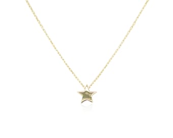 May include: A delicate gold chain necklace with a small, star-shaped pendant.