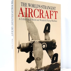 May include: A hardcover book titled "THE WORLD'S STRANGEST AIRCRAFT" with a sepia-toned image of a unique aircraft. The cover text is in red and black, with the author's name, Michael Taylor, at the bottom.