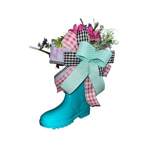 May include: A turquoise rain boot with a pink, white, and black checkered ribbon bow and a sign that says "Spring Flowers".
