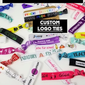 Puede incluir: Una colección de lazos de logotipo personalizados de colores vivos. Los lazos están hechos de material elástico y presentan una variedad de diseños, que incluyen texto, logotipos e imágenes. Los lazos son perfectos para agregar un toque personal a cualquier atuendo.