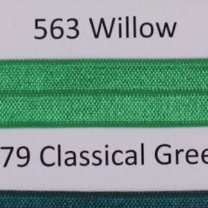 May include: A close-up of a fabric swatch card with three different colors of fabric. The top swatch is a light green color labeled "563 Willow". The middle swatch is a darker green color labeled "579 Classical Green". The bottom swatch is a yellow color labeled "660".