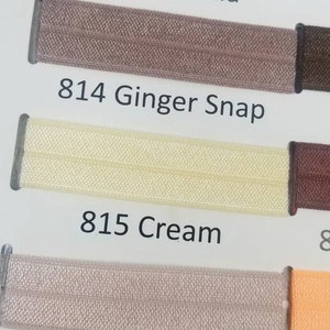May include: A color chart with swatches of different shades of brown, beige, and orange. The swatches are labeled with numbers and names, such as "761 Autumn Orange", "812 Natural", "813 Vanilla", "814 Ginger Snap", "815 Cream", "818 Carmandy", "823 Taupe", "824 Butterm", "845 Chipmu", "850 Brown", "868 Cappucc", and "A2268 Bisqu".