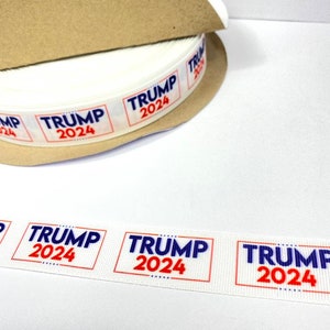 May include: A roll of white ribbon with the words "TRUMP 2024" printed in red and blue letters.