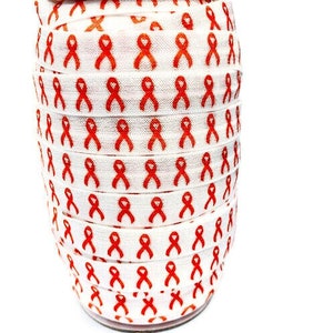 May include: A roll of white elastic with a repeating pattern of orange awareness ribbons.