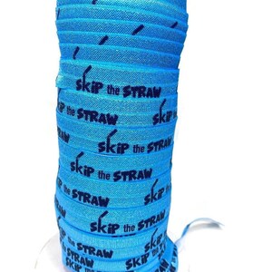 Puede incluir: Un rollo de elástico azul con las palabras "Skip the Straw" impresas en negro. El elástico está enrollado alrededor de un carrete blanco.