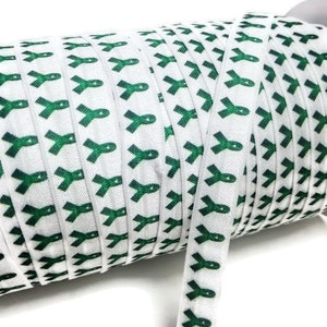 May include: A roll of white elastic ribbon with a repeating pattern of green awareness ribbons.