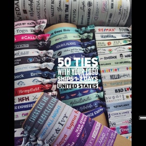 Op de afbeelding: Een verzameling kleurrijke stoffen polsbandjes met verschillende tekst en logo's. De tekst omvat "50 TIES", "WITH YOUR LOGO", "SHIPS 1-2 DAYS" en "UNITED STATES".
