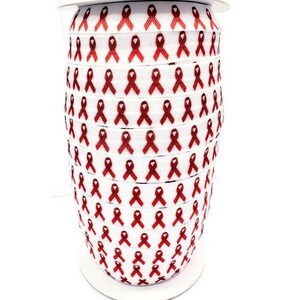 May include: A roll of white elastic ribbon with a repeating pattern of red awareness ribbons.