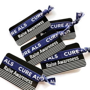 May include: Five black and white cards with blue elastic bands wrapped around them. The bands have the text "ALS CURE" and "Raise Awareness" printed on them.