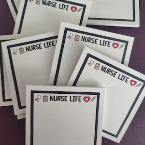 May include: A stack of white square sticky notes with a black border. Each note has a black and white illustration of a stethoscope, clipboard, heart, and syringe. The text "NURSE LIFE" is printed in black on each note.