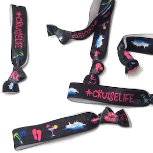 May include: Black and white elastic wristbands with colorful cruise-themed icons and the text "#CRUISELIFE" in pink.