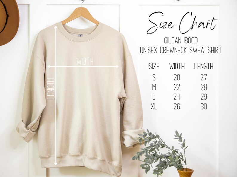 May include: A beige Gildan 18000 unisex crewneck sweatshirt hanging on a wooden hanger. The image includes a size chart with measurements in inches: S (20x27), M (22x28), L (24x29), XL (26x30). The words "Size Chart" are written in cursive.