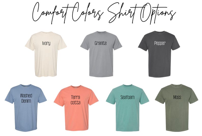 May include: A display of Comfort Colors t-shirts in various colors, including ivory, granite, pepper, washed denim, terracotta, seafoam, and moss. Each shirt has its color name printed on it in a simple font.