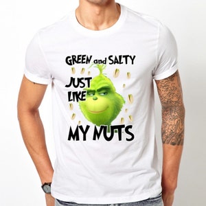 May include: White t-shirt with a green Grinch character and the text "GREEN and SALTY JUST LIKE MY NUTS".