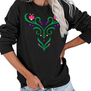 Op de afbeelding: Zwart longsleeve sweatshirt met een groen, paars en roze bloemenontwerp op de voorkant.