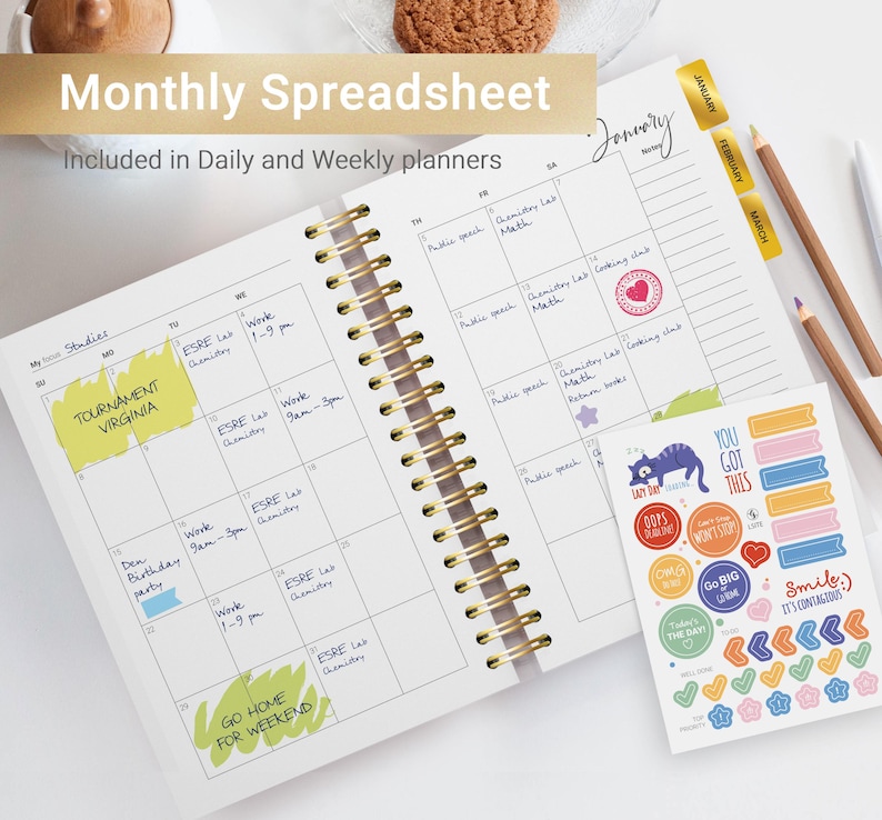 Pu&ograve; includere: Un'agenda mensile con una rilegatura a spirale dorata e una copertina bianca. L'agenda ha una griglia di calendario con note scritte a mano e note adesive colorate. Le note includono "Tournament Virginia", "Work 9am-3pm", "ESRE Lab Chemistry", "Den Birthday Party", "Work 1-9pm", "Go Home for Weekend", "Public Speech", "Chemistry Lab Math", "Cooking Club", "Return Books" e "January". L'agenda include anche un foglio di adesivi colorati con vari disegni, tra cui un gatto, un cuore e frecce.