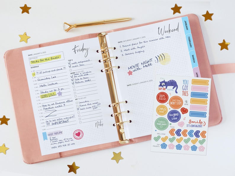 May include: A pink six-ring binder planner open to Friday and Saturday pages with handwritten notes, a gold pen with a diamond-shaped topper, and a sheet of colorful stickers featuring various shapes, icons, and motivational text like You Got This.