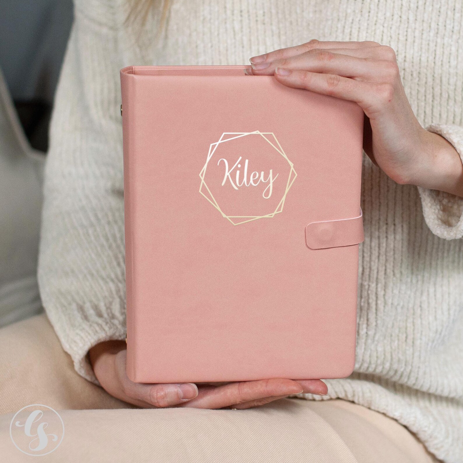 A person holding a pink planner