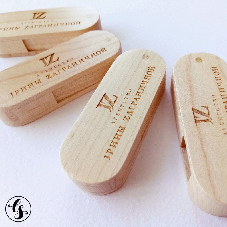 Puede incluir: Cuatro unidades flash USB de madera con el texto "АГЕНТСТВО ИРИНЫ ЗАГРАНИЧНОЙ" y la letra "JZ" grabadas en ellas.