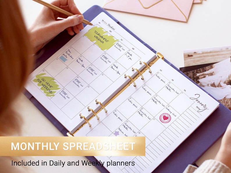 May include: A purple ring-bound planner open to a January monthly calendar page with handwritten notes, yellow highlighter marks, and a red heart stamp. The planner features gold-toned metal rings and white paper with black grid lines and text.