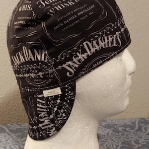 May include: A white ceramic mug with a black handle and the text "But First, Coffee" in a black, bold font. The mug is sitting on a wooden surface. The mug is approximately 4 inches tall.